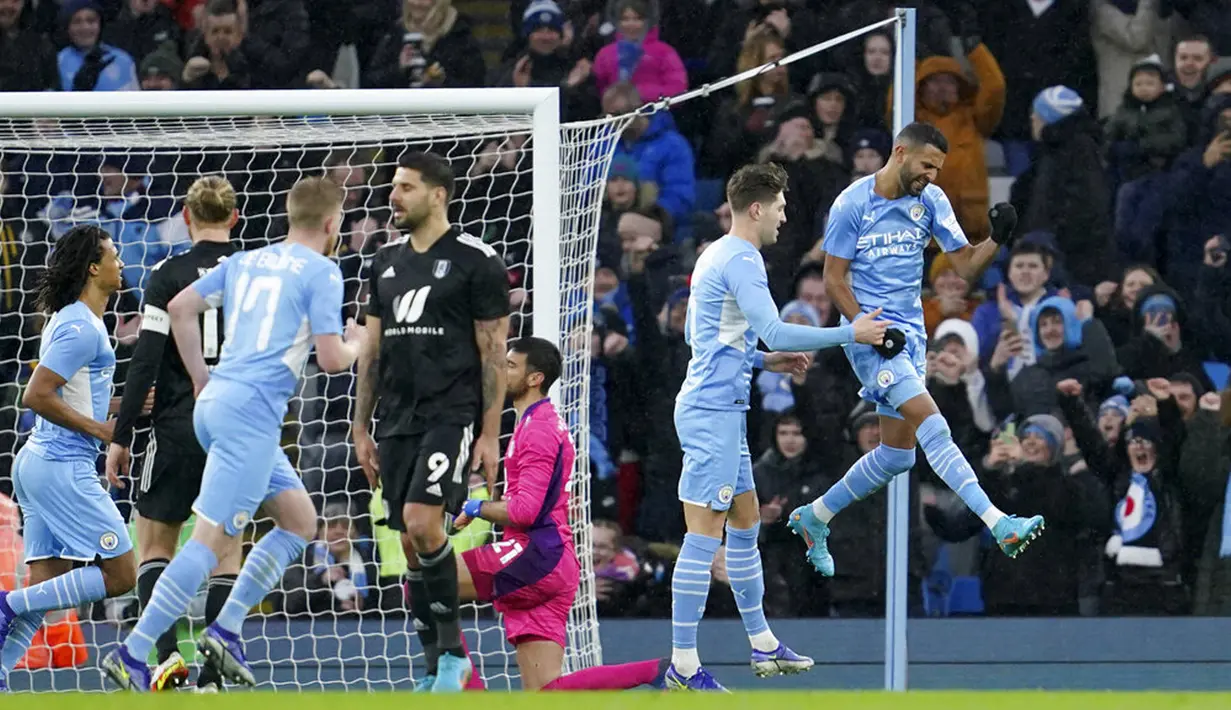 Pemain Manchester City Riyad Mahrez (kanan) melakukan selebrasi usai mencetak gol ke gawang Fulham dari titik penalti pada pertandingan sepak bola putaran keempat Piala FA di Etihad Stadium, Manchester, Inggris, 5 Februari 2022. Manchester City menang 4-1. (AP Photo/Jon Super)