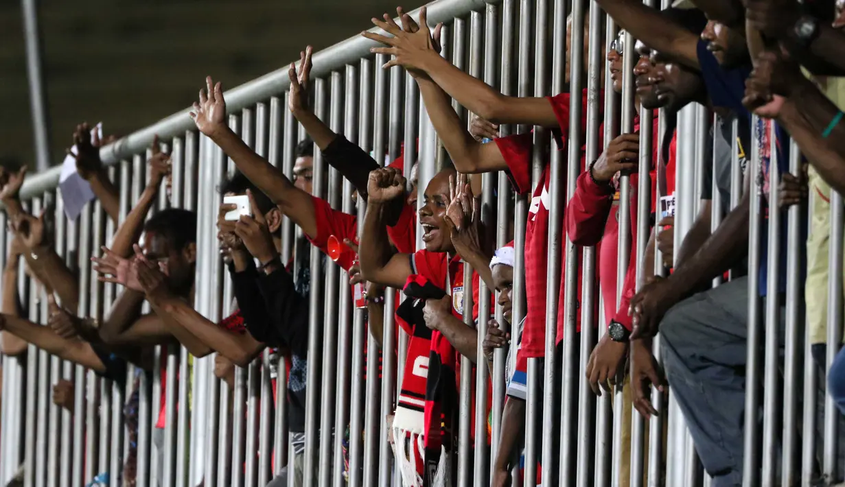 Suporter Persipura memberi dukungan kepada timnya dari pagar besi pada lanjutan Piala Jenderal Sudirman grup E  di Stadion Sleman, Yogyakarta, Minggu (13/12/2015). (Bola.com/Nicklas Hanoatubun)