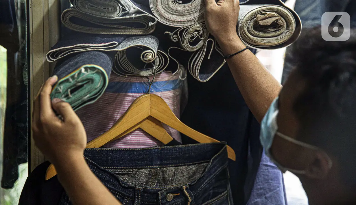 Penjahit memilih bahan yang akan dijahit di Nyoel Jeans co, Jakarta, Jumat (22/10/2021). Kapas adalah salah satu bahan baku utama pembuatan kain dalam industri tekstil di Indonesia. (Liputan6.com/Faizal Fanani)
