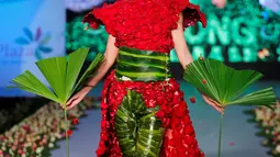 Seorang model berjalan diatas catwalk mengenakan busana yang terbuat dari aneka daun dan bunga yang dominan berwarna merah saat pergelaran Biofashion di Cali, Kolombia (19/11). (Reuters/Jaime Saldarriaga)