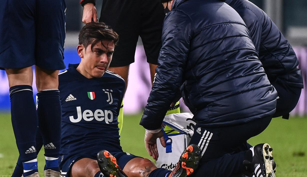 Striker Juventus, Paulo Dybala mendapat penanganan dari tim medis usai mengalami cedera dalam laga lanjutan Liga Italia Serie A 2020/21 pekan ke-17 melawan Sassuolo di Juventus Stadium, Minggu (10/1/2021). Juventus menang 3-1 atas Sassuolo. (AFP/Marco Bertorello)