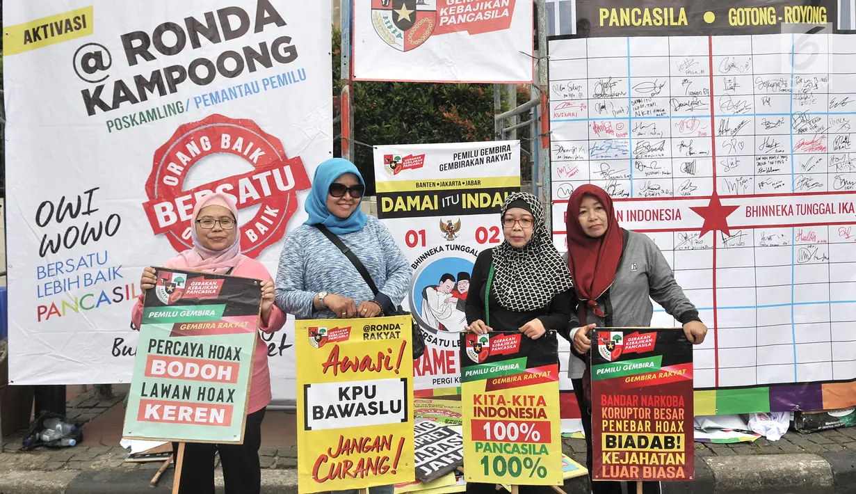 Warga membawa poster pada saat kampanye Pemilu Damai pada CFD di kawasan Bundaran HI, Jakarta, Minggu (17/3). Kampanye yang digelar Gerakan Kebijakan Pancasila mengajak masyarakat untuk menjaga pemilu dari hoax. (merdeka.com/Iqbal S Nugroho)
