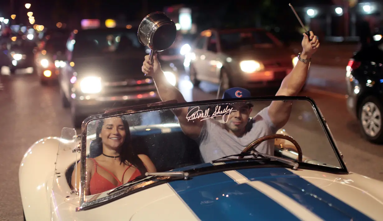 Warga Kuba berada di mobil bersorak saat turun ke jalan merayakan wafatnya Fidel Castro di Miami, AS (26/11). Wafatnya pemimpin revolusi komunis Kuba tidak ditanggapi dengan kesedihan oleh warga Kuba yang menetap di Miami. (REUTERS/Javier Galeano)