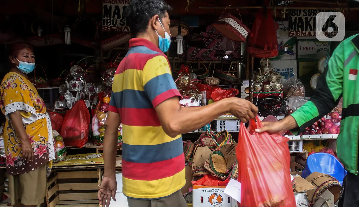 Pekerja melayani pembeli parcel buah dan vitamin ditoko buah miliknya di Jalan Barito, Jakarta, Minggu (11/7/2021).  Peningkatan omset disebabkan oleh banyaknya warga yang melakukan isolasi mandiri dan menjadikan buah sebagai sumber asupan vitamin C. (Liputan6.com/Johan Tallo)