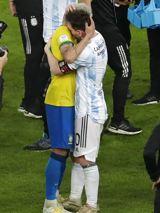 Penyerang Argentina, Lionel Messi memeluk pemain Brasil, Neymar pada pertandingan final Copa America 2021 di stadion Maracana di Rio de Janeiro, Brasil, Minggu (11/7/2021). Messi, yang juara bersama Argentina, ikut menghibur Neymar. (AP Photo/Silvia Izquierdo)