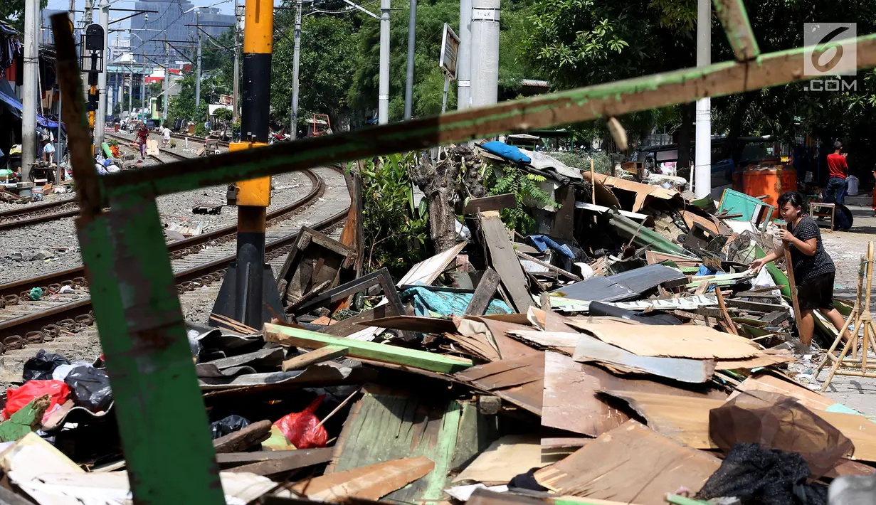 Warga menyelesaikan bongkaran bangunan liar di area Rusun Bendungan Hilir (Benhil) II, Jakarta, Minggu (3/12). Bangunan liar tersebut dibongkar karena berdiri di atas lahan PT Kereta Api Indonesia (PT KAI). (Liputan6.com/JohanTallo)
