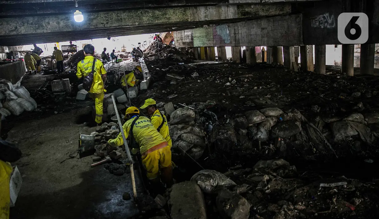 Aktivitas penataan kolong jembatan usai dihuni pemulung di Kelurahan Pegangsaan, Kecamatan Menteng, Jakarta, Kamis (7/1/2021). Penataanjuga dilakukan untuk menjadikan kolong jembatan tersebut taman dan akses jalan bagi warga serta tempat penyeberangan orang. (Liputan6.com/Faizal  Fanani)