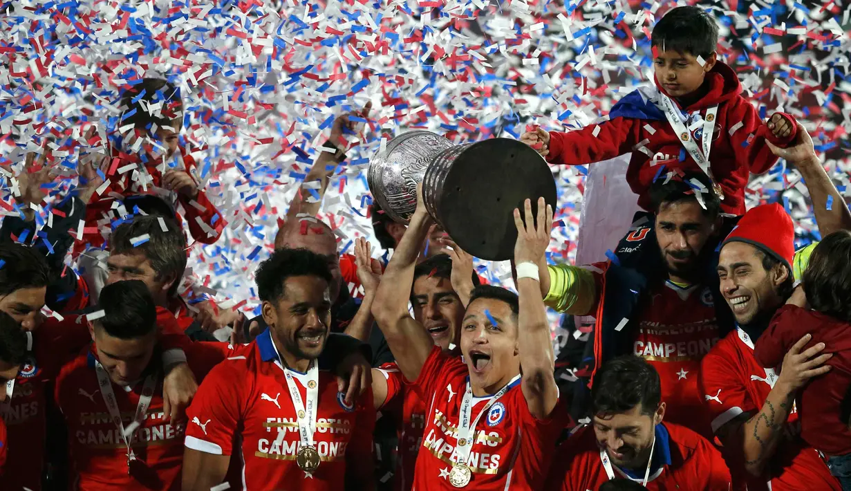 Alexis Sanchez mengangkat trofi merayakan kemenangan usai mengalahkan Argentina di Final Copa America 2015 di Stadion Nasional, Santiago, Chili, (4/7/2015). Chili menang lewat adu penalti atas Argentina dengan skor 4-1. (REUTERS/Ueslei Marcelino)