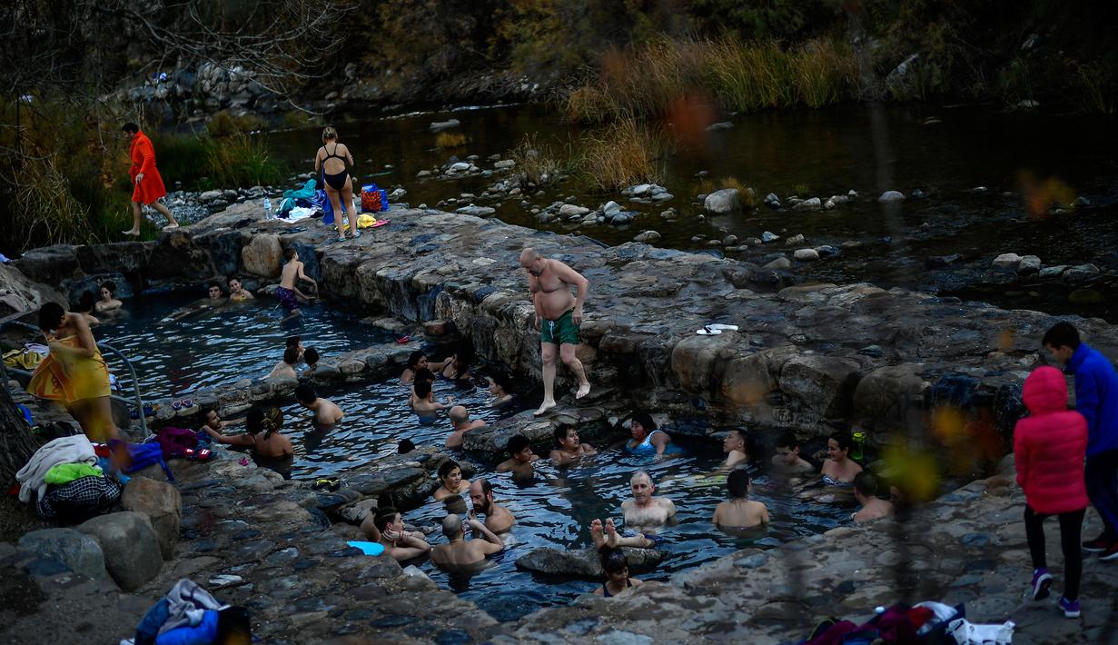 Orang-orang menikmati pemandian air panas alami Sungai Cidaco dengan suhu 52 Celcius saat pagi musim dingin di desa kecil Arnedillo, Spanyol utara, 29 Desember 2018. (AP Photo/Alvaro Barrientos)