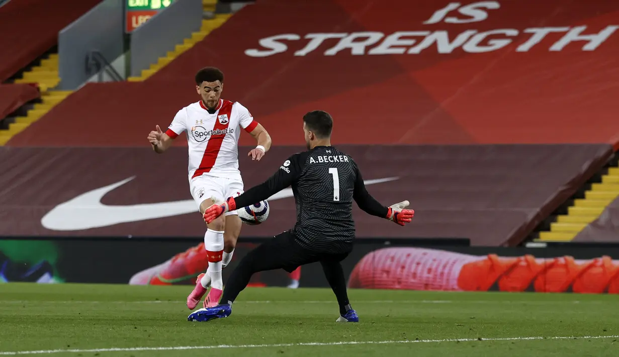 Kiper Liverpool Alisson berusaha menyelamatkan bola tendangan pemain Southampton, Che Adams pada pertandingan lanjutan Liga Inggris di stadion Anfield di Liverpool, Inggris, Minggu (9/5/2021). Sedangkan Southampton masih terpuruk di perigkat ke-16 dengan torehan 37 poin. (Phil Noble / Pool via AP)