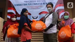 Perwakilan Jurnalis Peduli (kanan) memberikan bantuan paket sembako BNI di Pulau Panggang, Kepulauan Seribu, Kamis (10/9/2022). Paket sembako dan perlengkapan new normal diharapkan dapat membantu warga terdampak pandemi Covid-19 yang saat ini semakin naik. (Liputan6.com/HO/JurnalisPeduli)