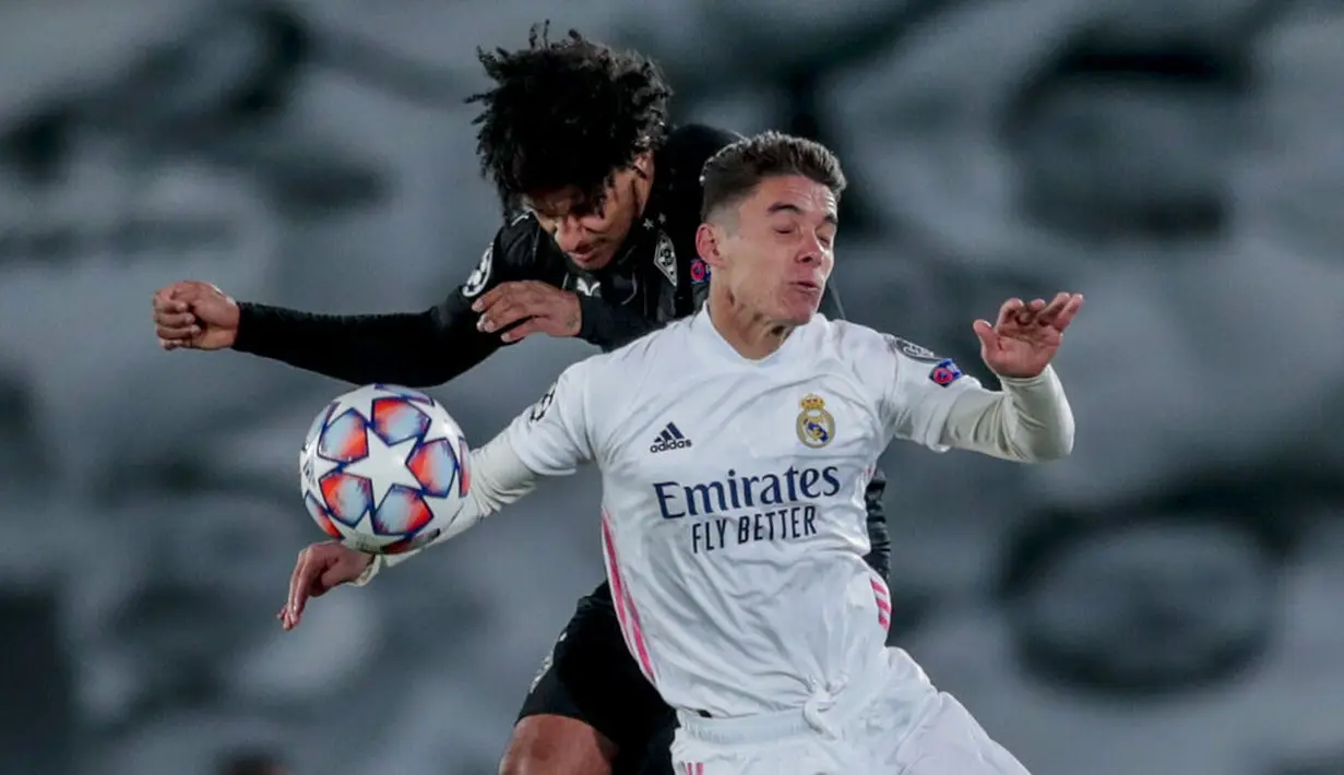Pemain Real Madrid, Sergio Arribas Calvo, duel udara dengan pemain Borussia Monchengladbach, Valentino Lazaro, pada laga Liga Champions di Stadion Alfredo Di Stefano, Kamis (10/12/2020). Real Madrid menang dengan skor 2-0. (AP/Bernat Armangue)