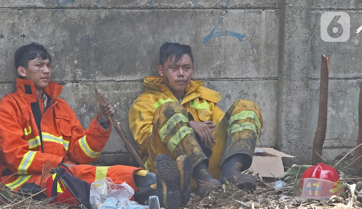Petugas pemadam kebakaran beristirahat usai memadamkan api di lapak ban bekas, Desa Bojong Nangka, Gunung Putri, Bogor, Kamis (22/4/2021). Banyaknya bahan yang mudah terbakar dan sumber api yang berasal dari bawah tumpukan ban membuat  api di lokasi belum juga padam. (Liputan6.com/Herman Zakharia)