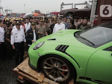 Menkeu Sri Mulyani didampingi Menhub Budi Karya Sumadi mengecek barang bukti kasus penyelundupan mobil dan motor mewah, Terminal Petikemas Koja, Jakarta, Selasa (17/12/2019). Bea Cukai menggagalkan penyelundupan 19 unit mobil mewah, 35 unit motor mewah, rangka, dan mesin. (merdeka.com/Iqbal Nugroho)