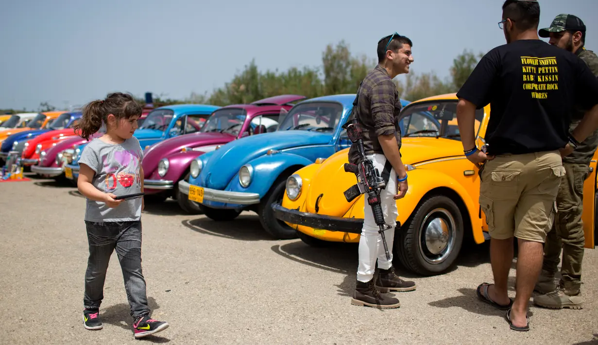 Seorang anak berjalan diantara mobil Volkswagen Beetle dalam ajang pertemuan tahunan "Beetle club" di Yakum, Israel tengah (21/4). Dalam pertemuan ini mereka memamerkan mobil Volkswagen Beetle dengan aneka modifikasi. (AP Photo / Oded Balilty)