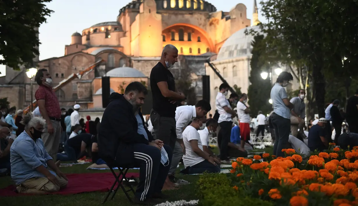 Umat Muslim melaksanakan salat di luar Hagia Sophia era Bizantium, di distrik bersejarah Sultanahmet Istanbul, Kamis, 23 Juli 2020, sehari sebelum sholat Muslim pertama di monumen tengara dalam 86 tahun setelah konversi kembali menjadi masjid. (AP Photo/Omer Kuscu)