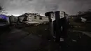 Sebuah truk tergeletak di depan rumah yang hancur setelah tornado menyapu daerah di Arabi, La., (22/3/2022). Tornado menerjang bagian New Orleans dan sekitarnya Selasa malam, menghancurkan kabel listrik dan menyebarkan puing-puing di bagian kota. (AP Photo/Gerald Herbert)