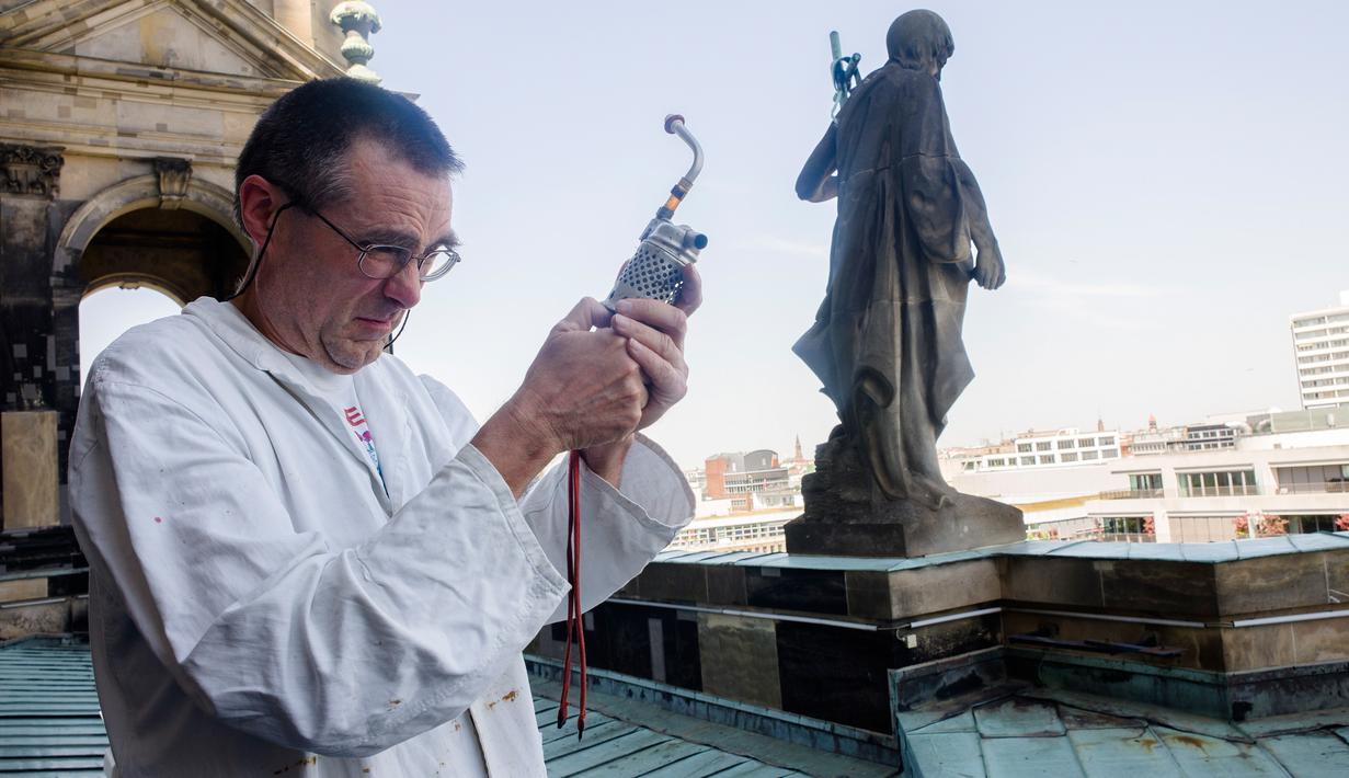 Peternak lebah, Uwe Marth menyiapkan pipa peternak lebahnya di atap Katedral Berlin di Berlin, 14 Mei 2018. Seseorang tidak akan mengira kalau ibu kota Jerman itu adalah lokasi ideal untuk beternak lebah dan produksi madu. (AP/Markus Schreiber)