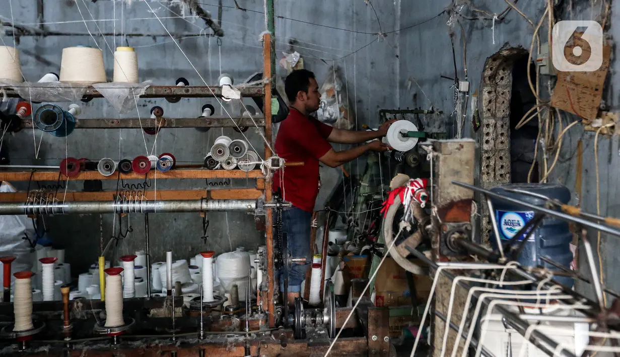 Pekerja memintal benang di Kebayoran, Jakarta, Selasa (5/7/2022). Pabrik benang yang berdiri sejak tahun 1970-an tersebut dapat memproduksi 100 kilogram benang dalam sehari dan dipasarkan ke berbagai daerah di Indonesia. (Liputan6.com/Johan Tallo)