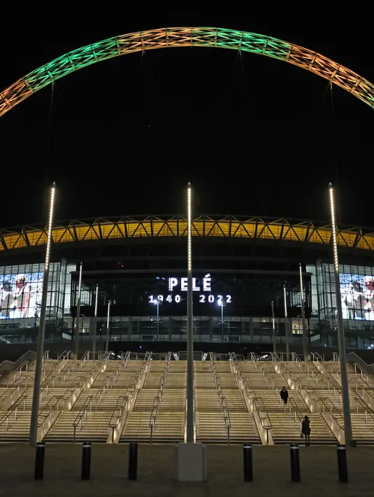 Lengkungan Stadion Wembley menyala dalam warna Brasil dan layar menampilkan gambar Pele setelah pengumuman bahwa mantan pemain sepak bola Brasil itu meninggal dunia, London, Inggris, 29 Desember 2022. Edson Arantes do Nascimento atau yang dikenal sebagai Pele, raja sepak bola Brasil yang menang rekor tiga Piala Dunia dan menjadi salah satu tokoh olahraga paling berwibawa abad lalu, meninggal pada usai 82 tahun di di Sao Paulo. (Kieran Cleeves/PA via AP)
