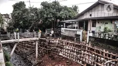 Warga mengamati turap kali yang longsor di Batu Ampar, Kramat Jati, Jakarta, Selasa (23/2/2021). Turap kali sepanjang 30 meter di permukiman RT 17 dan 13 RW 02 Kelurahan Batu Ampar longsor pada Sabtu (20/2) akibat derasnya arus air ketika aliran Kali Ciliwung meluap. (merdeka.com/Iqbal S. Nugroho)