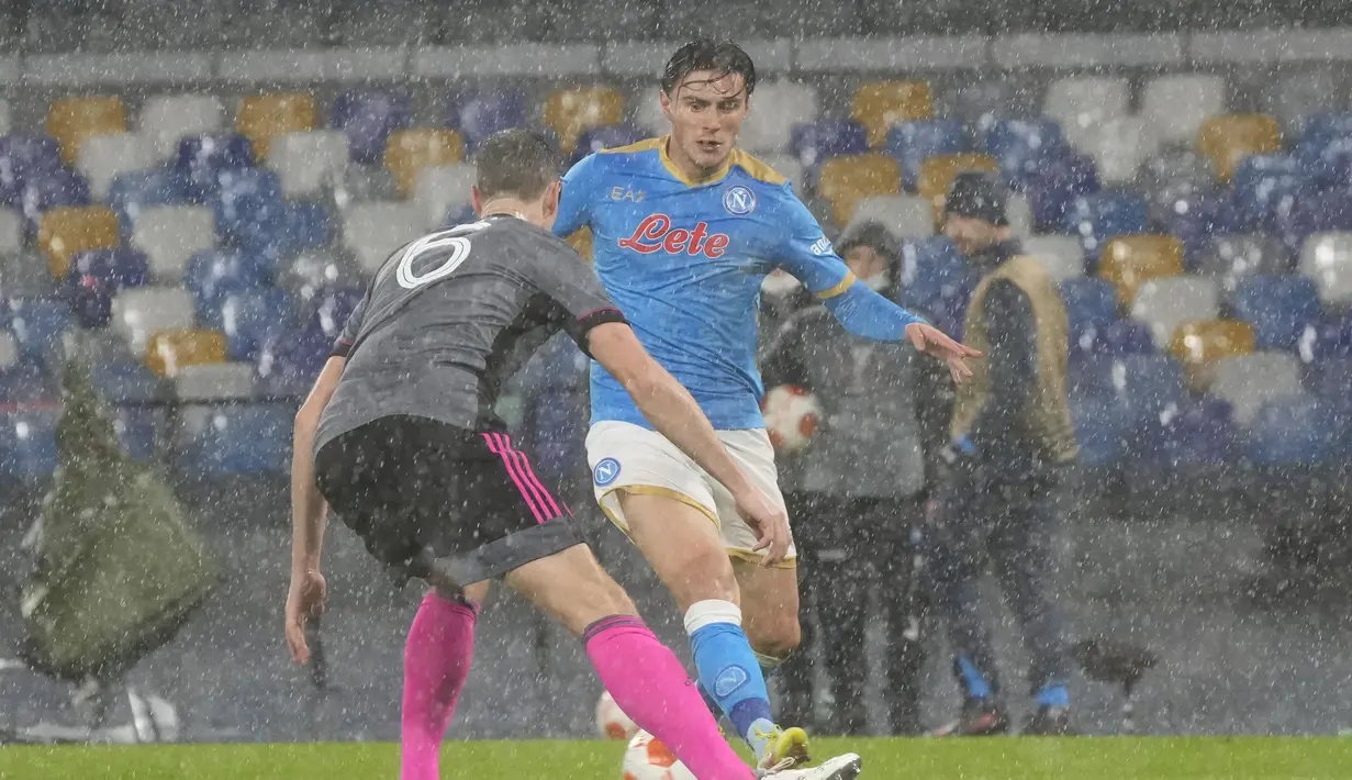 Gelandang Napoli, Piotr Zielinski berusaha melewati bek Leicester City, Jonny Evans pada pertandingan Grup C Liga Europa di Stadion Diego Armando Maradona di Naples, Italia (10/12/2021). Napoli melaju kebabak selanjutnya karena berada diperingkat kedua klasemen. (AP Photo/Gregorio Borgia)