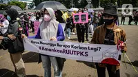 Massa dari Jaringan Pembela Hak Perempuan Korban Kekerasan Seksual membentangkan spanduk di depan Gedung DPR, Jakarta, Rabu (22/12/2021). Mereka mendesak DPR mengesahkan rancangan undang-undang Tindak Pidana Kekerasan Seksual (RUU TPKS) sebagai RUU Inisiatif DPR RI (Liputan6.com/Faizal Fanani)