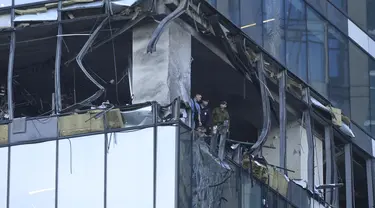 Penyelidik memeriksa gedung pencakar langit yang rusak di kawasan bisnis "Kota Moskow" setelah serangan drone yang dilaporkan di Moskow, Rusia, Minggu dini hari (30/7/2023). (AP Photo)