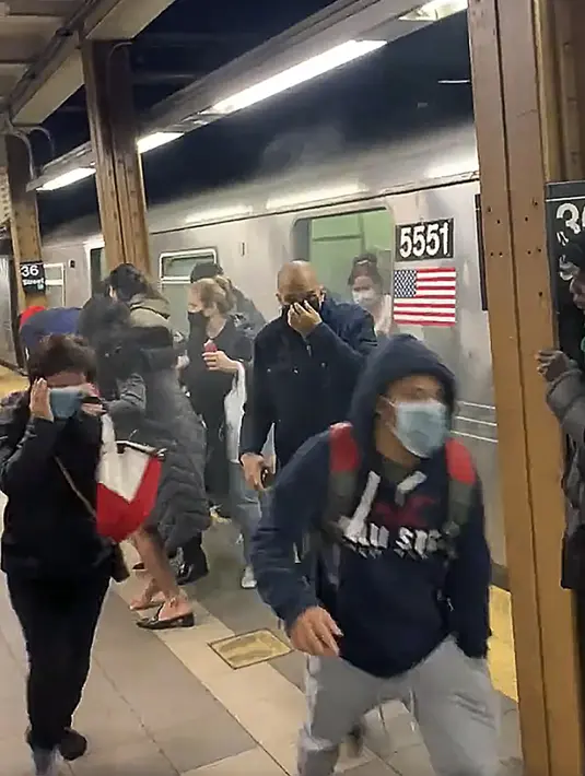 Penumpang berlari dari gerbong kereta bawah tanah di sebuah stasiun di wilayah Brooklyn, New York, Amerika Serikat, 12 April 2022. Polisi masih melakukan pengejaran terhadap pelaku penembakan. (Will B Wylde via AP)