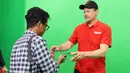 Wartawan Bola.com, Abdul Aziz, memberikan clip on saat wawancara eksklusif dengan kiper legendaris Manchester United, Peter Schmeichel, di SCTV Tower, Jakarta, Jumat (4/8/2023). (Bola.com/M Iqbal Ichsan)