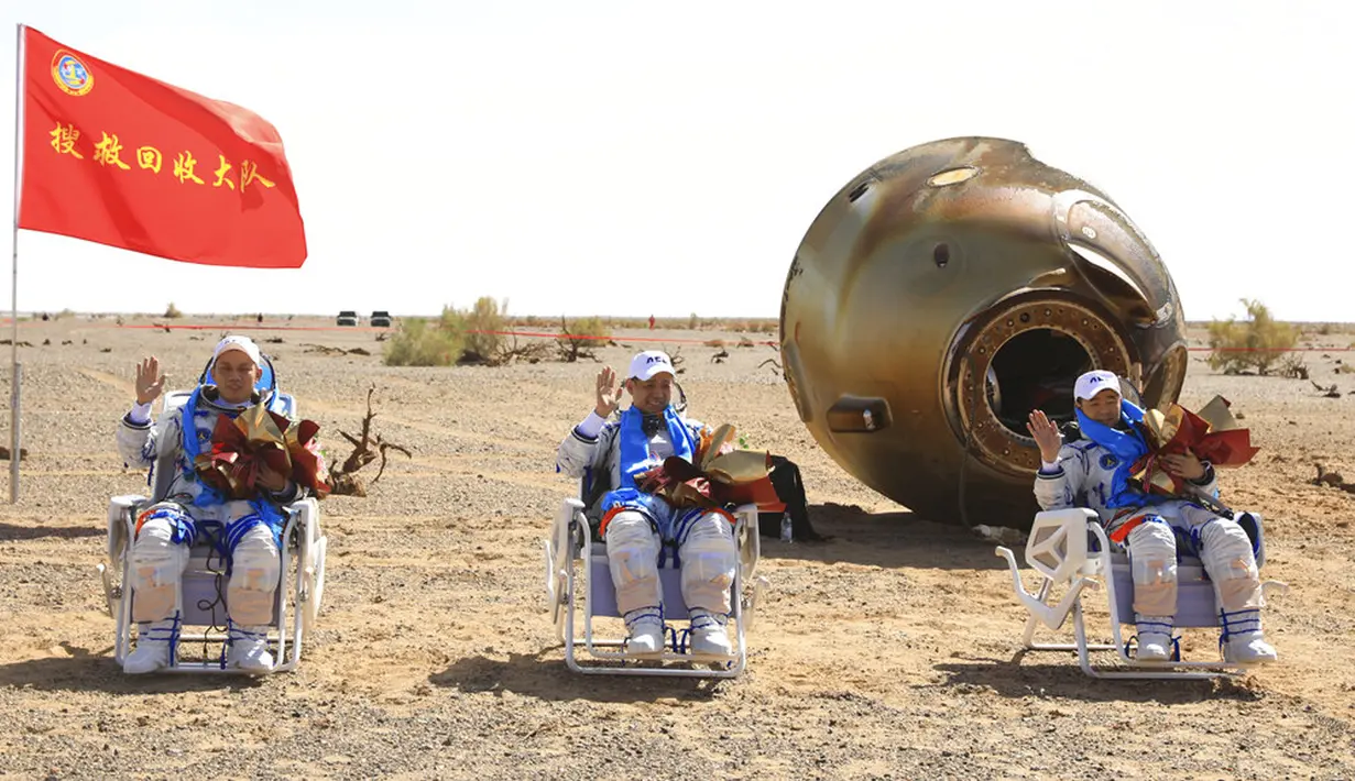 Astronot China Tang Hongbo (kiri), Nie Haisheng (tengah), dan Liu Boming (kanan) melambai di lokasi pendaratan Dongfeng di Daerah Otonomi Mongolia Dalam, China, 17 September 2021. Trio astronot China kembali ke Bumi setelah misi luar angkasa. (Ju Zhenhua/Xinhua via AP)