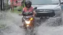 Pengendara bermotor melewati banjir di Jalan Cinere Raya (depan Mall Cinere), Depok, Jawa Barat, Minggu (31/3). Banjir terjadi akibat sistem drainase yang buruk. (merdeka.com/Arie Basuki)