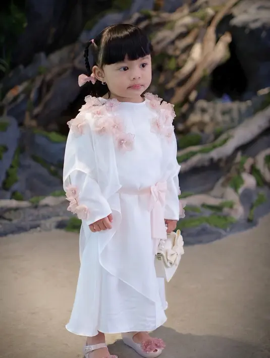 Tampil dalam balutan dress nuansa pink-putih di acara pengajian-siraman Aaliyah dan Thariq, penampilan Ameena makin gemas dengan mini handbag warna putih. [@aurelie.hermansyah/@sus.irohh].