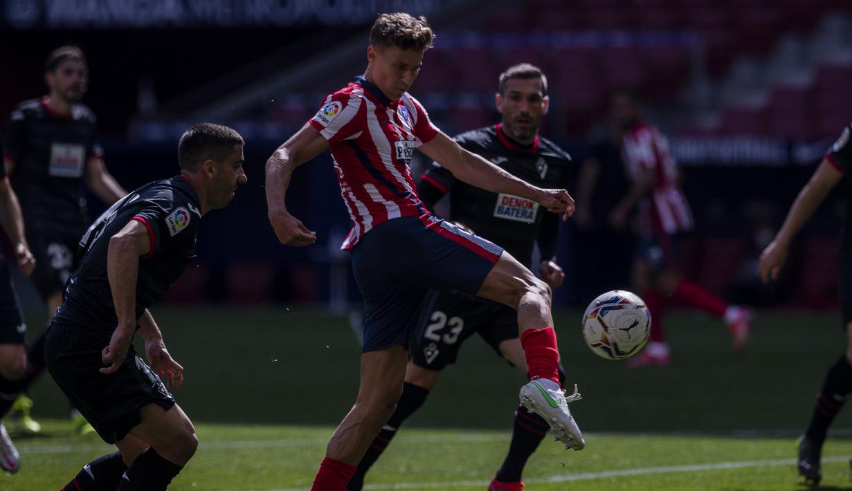 Gelandang Atletico Madrid, Marcos Llorente (tengah) melepaskan tendangan ke gawang Eibar dalam laga lanjutan Liga Spanyol 2020/2021 pekan ke-31 di Wanda Metropolitano Stadium, Madrid, Minggu (18/4/2021). Atletico menang 5-0 atas Eibar. (AP/Bernat Armangue)