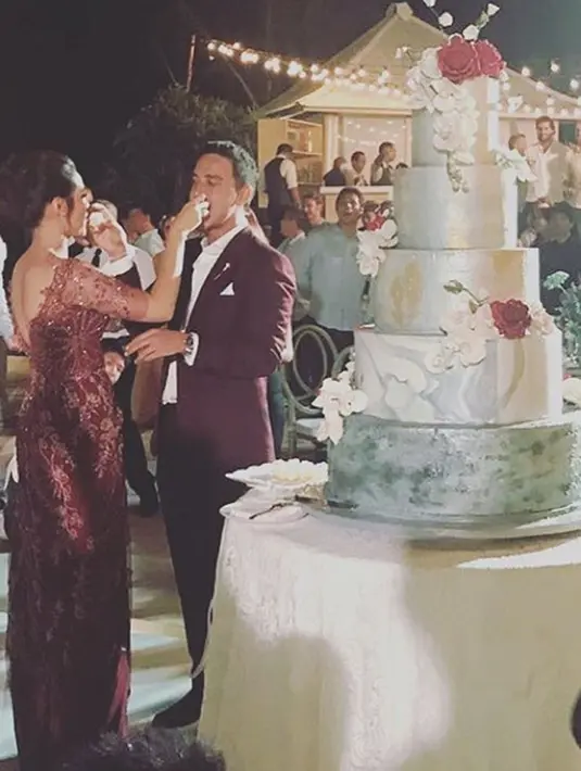 Suasana romantis semakin terlihat saat sesi pemotongan kue pengantin yang bertingkat. Setelah itu Raisa dan Hamish pun saling menyuapkan potongan kue tersebut sambil melempar senyum bahagia. (Instagram/_yourraisa)