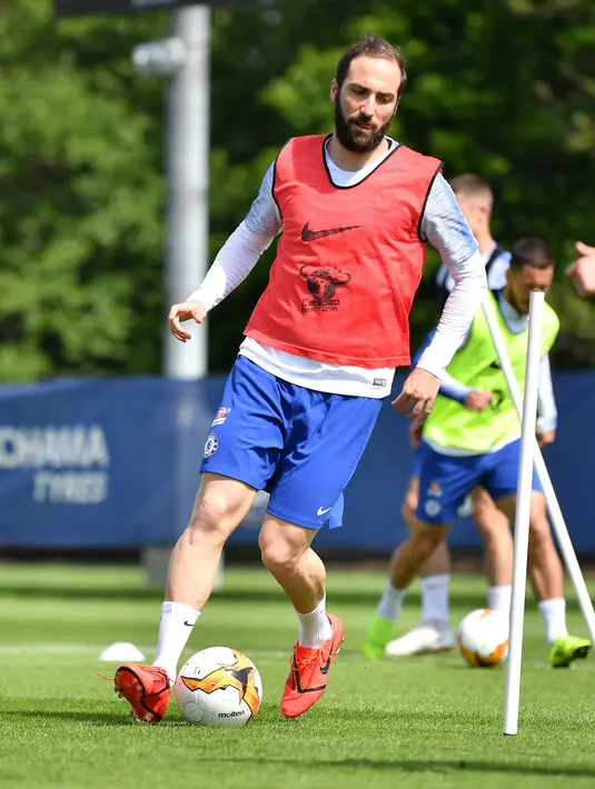 Penyerang Chelsea, Gonzalo Higuain menggiring bola saat mengikuti latihan tim di Chelsea Training Ground, di Cobham, Surrey (22/5/2019). Chelsea akan bertanding melawan Arsenal pada babak Final Liga Europa pada 29  Mei di Baki Olimpiya Stadionu. (AFP Photo/Ben Stansall)