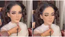 Wajah cantik Putri Isnari di hari bahagianya ini dipoles oleh MUA Adela Angra. Ini adalah potret Putri ketika proses makeup. Meski belum sempurna, namun aura Putri Isnari sudah terpancar bahkan wajahnya sangat berbeda. Tampil memukau di hari pernikahannya, tak sedikit netizen yang memuji penampilan dan tema resepsi pernikahan penyanyi kelahiran 2004 ini. (Liputan6.com/IG/@adelahaddad17)