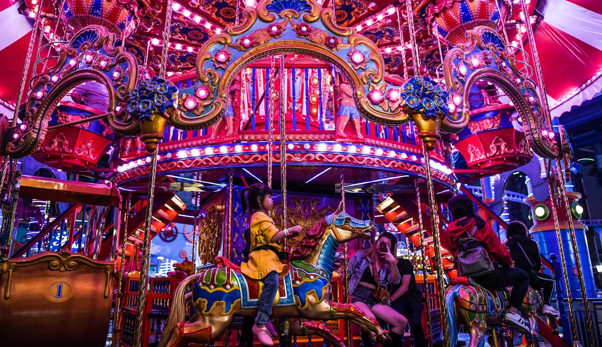 Anak-anak bermain wahana kuda putar di Skytropolis Funland di resor Genting Highlands, Kuala Lumpur, Malaysia (30/6/2019). Di dalam Skytropolis Funland, ada sekitar 21 wahana yang terbagi menjadi tiga bagian, antara lain Child Rides, Family Rides, dan Thrill Rides. (AFP Photo/Mohd Rasfan)