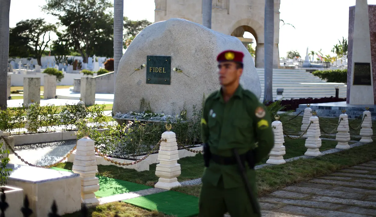 Anggota militer berjaga-jaga di dekat batu granit besar, tempat abu Fidel Castro diletakan, di pemakaman Santa Ifigenia, Santiago, Kuba, (4/12). Fidel Castro meninggal pada usia 90 tahun. (REUTERS/Ivan Alvarado)