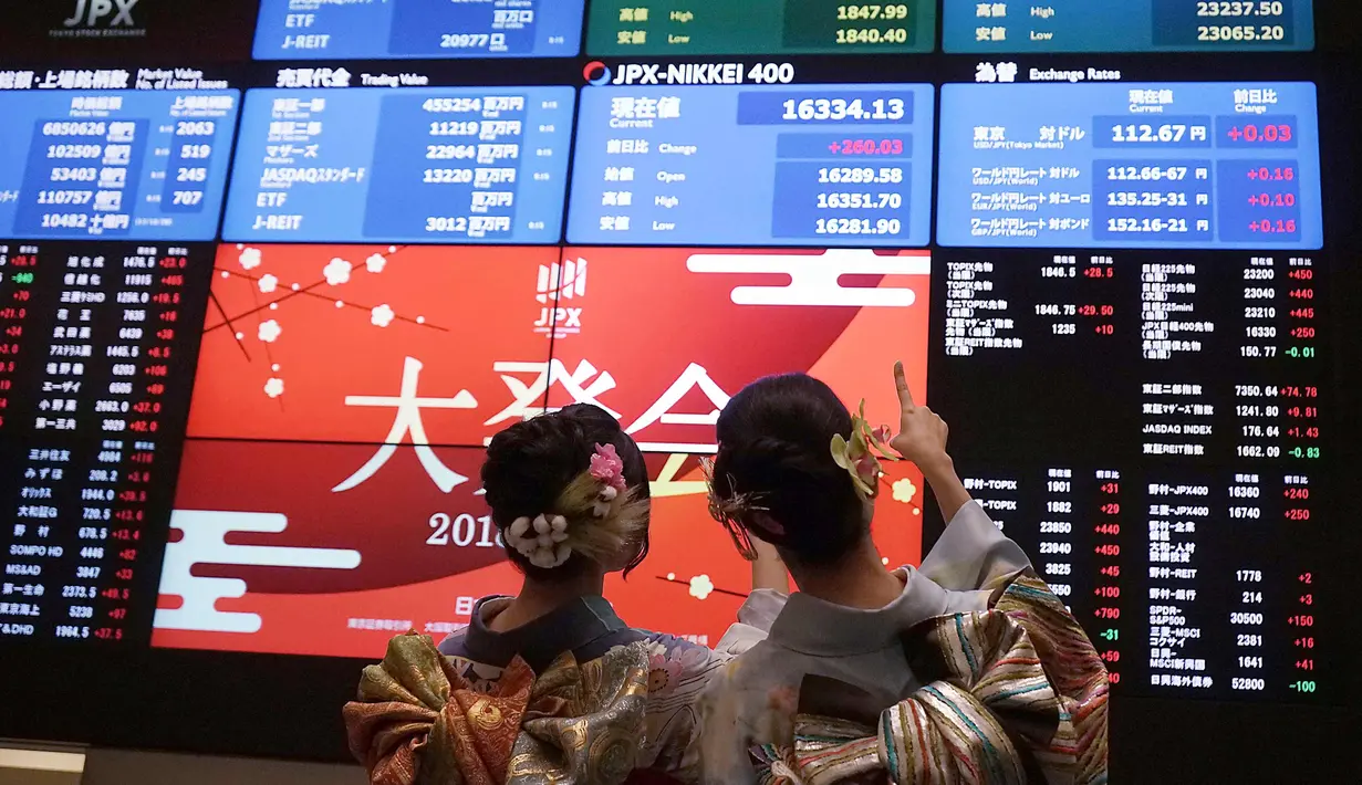Dua wanita berbusana kimono melihat pergerakan saham pada pembukaan pasar saham untuk tahun ini di Bursa Saham Tokyo, Jepang (4/1). (AP Photo/Eugene Hoshiko)