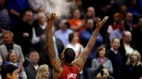 Small Forward Cleveland Cavaliers, LeBron James, melalukan 'chalk toss' ke udara sebelum pertandingan dimulai. (EPA/Jason Szenes)