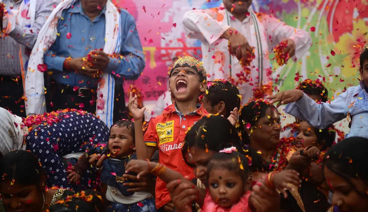 Anak-anak India bermain dengan kelopak bunga di sebuah acara untuk merayakan festival Hindu Holi untuk anak-anak cerebral palsy yang diselenggarakan oleh Yayasan Trishla di Allahabad (25/2). (AFP Photo/Sanjay Kanojia)