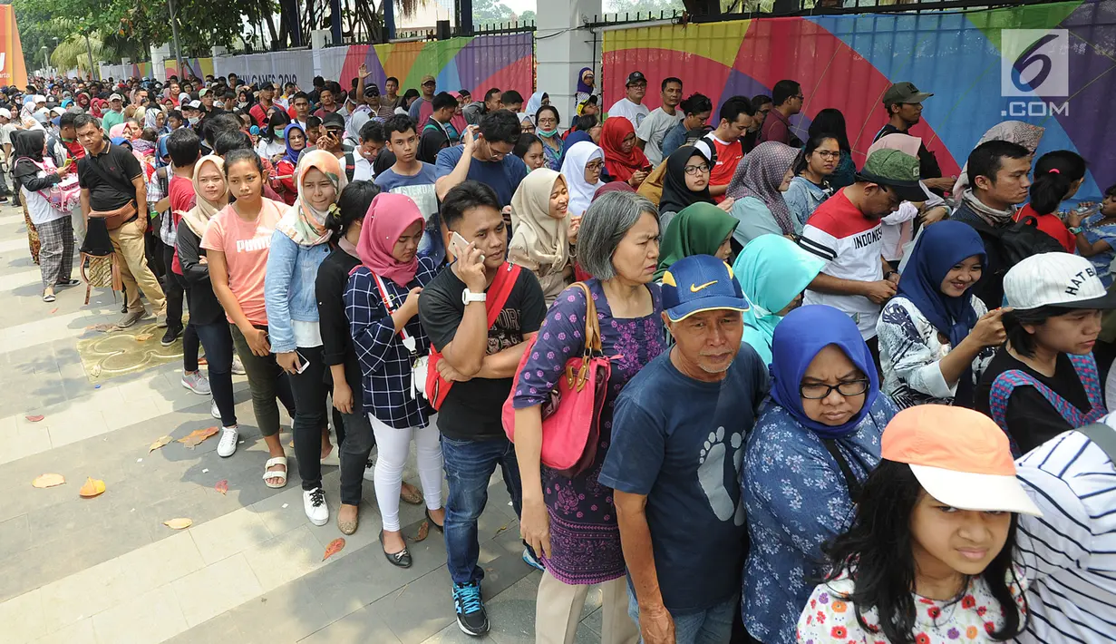 Calon penonton rela antre di sepanjang pendestrian Senayan untuk mengikuti Closing Ceremony Asian Games 2018, di Stadion GBK, Jakarta, Minggu (2/9). Mereka rela antre sejak pukul 08.00 pagi menuju Puntu 7. (merdeka.com/Arie Basuki)