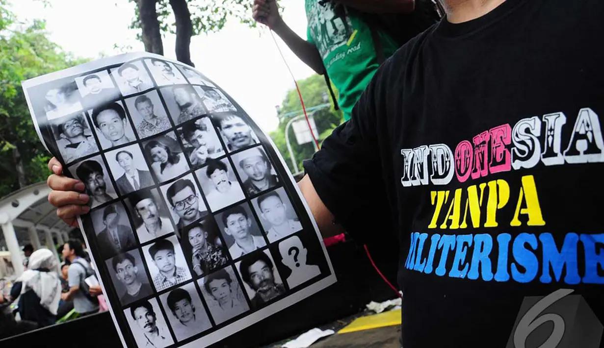 Seorang pendemo membawa poster berisi foto-foto orang yang hilang pada zaman Orde Baru, Jakarta, Senin (7/7/2014) (Liputan6.com/Faizal Fanani) 