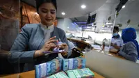 Teller Bank BTN menghitung uang pecahan baru untuk melayani kebutuhan nasabah di Kantor Cabang Bank BTN Harmoni, Jakarta (26/4/2023). (Liputan6.com)