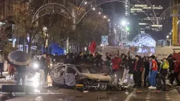 Para suporter itu emosi dan beramai-ramai turun ke jalan untuk melampiaskan kekesalannya dengan cara melempari, merusak dan membakar benda-benda di sekitarnya termasuk mobil. (AP/Geert Vanden Wijngaert)