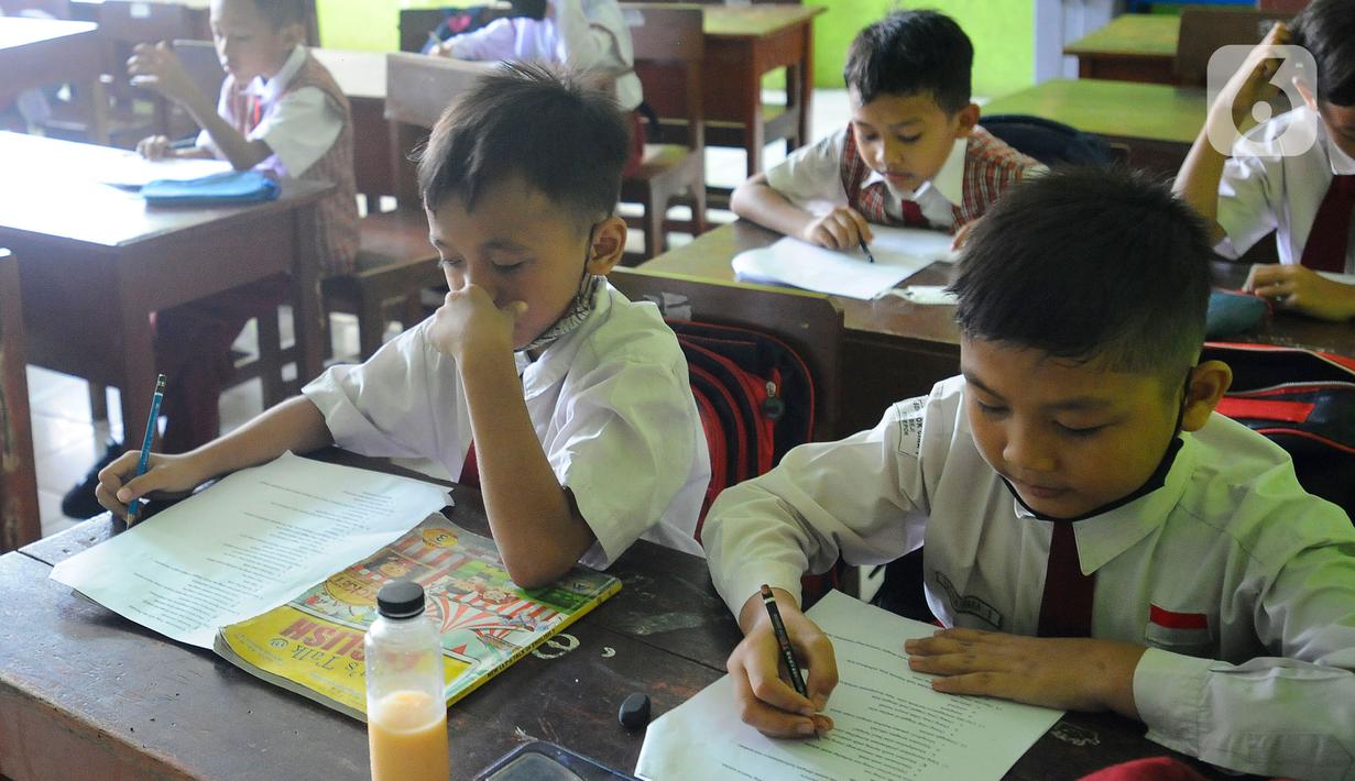 Siswa mengerjakan ujian penilaian akhir semester (PAS) yang dihadiri guru pengawas di SDN Pondok Cina 1 Depok, Jawa Barat, Senin (5/12/2022). Mulai 5 - 9 Desember 2022, para siswa sekolah dasar itu akan melaksanakan ujian penilaian akhir semester (PAS). (merdeka.com/Arie Basuki)