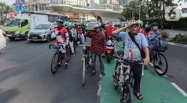 Pengendara berhenti selama tiga menit saat prosesi mengheningkan cipta untuk menghormati detik-detik proklamasi dalam HUT ke-78 Kemerdekaan RI di kawasan Bundaran HI, Jakarta, Kamis (17/8/2023). (Liputan6.com/Faizal Fanani)