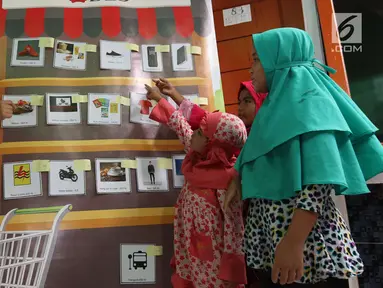 Karyawan mengajar mengelola keuangan melalui Kedai DBS kepada anak-anak di yayasan Rumpun Anak Pesisir di Jakarta Utara, Selasa (17/7). Anak-anak diajarkan bagaimana mengelola keuangan secara sederhana. (Liputan6.com/Angga Yuniar)