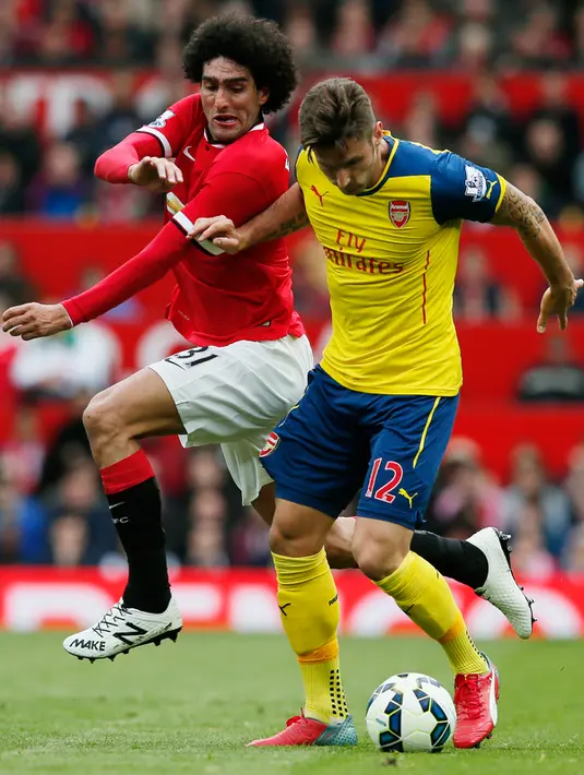 Penyerang Arsenal, Oliver Giroud (kanan) berusaha melewati gelandang Marouane Fellaini saat Laga Liga Premier Inggris di Stadion Old Trafford, Minggu (17/5/2015). Manchester United bermain imbang 1-1 atas Arsenal. (Reuters/Jason Cairnduff)